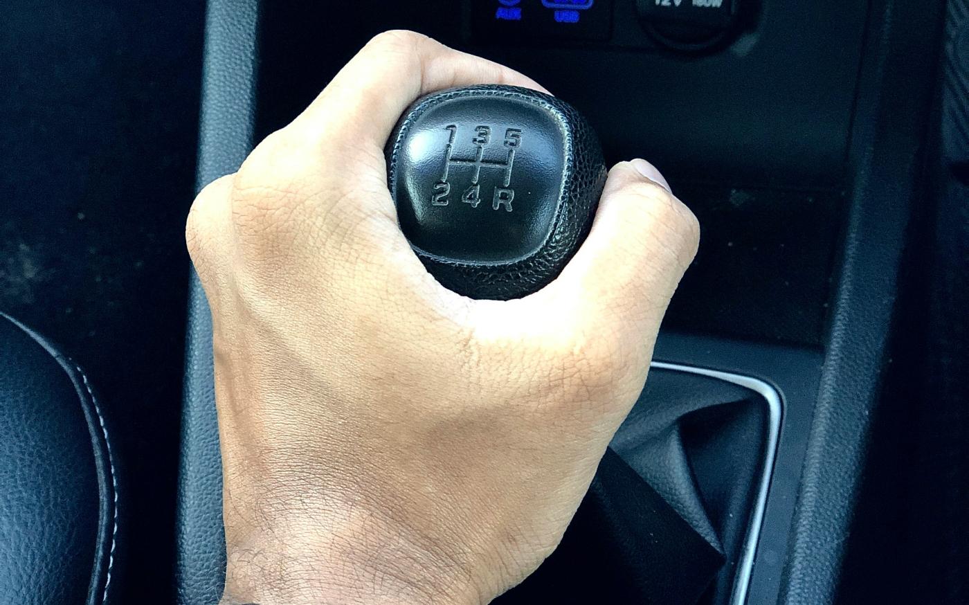 person holding black car gear shift lever by DICSON courtesy of Unsplash.