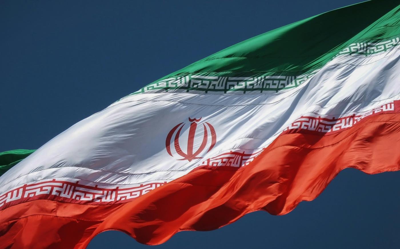 the flag of the country of iraq flying in the sky by sina drakhshani courtesy of Unsplash.