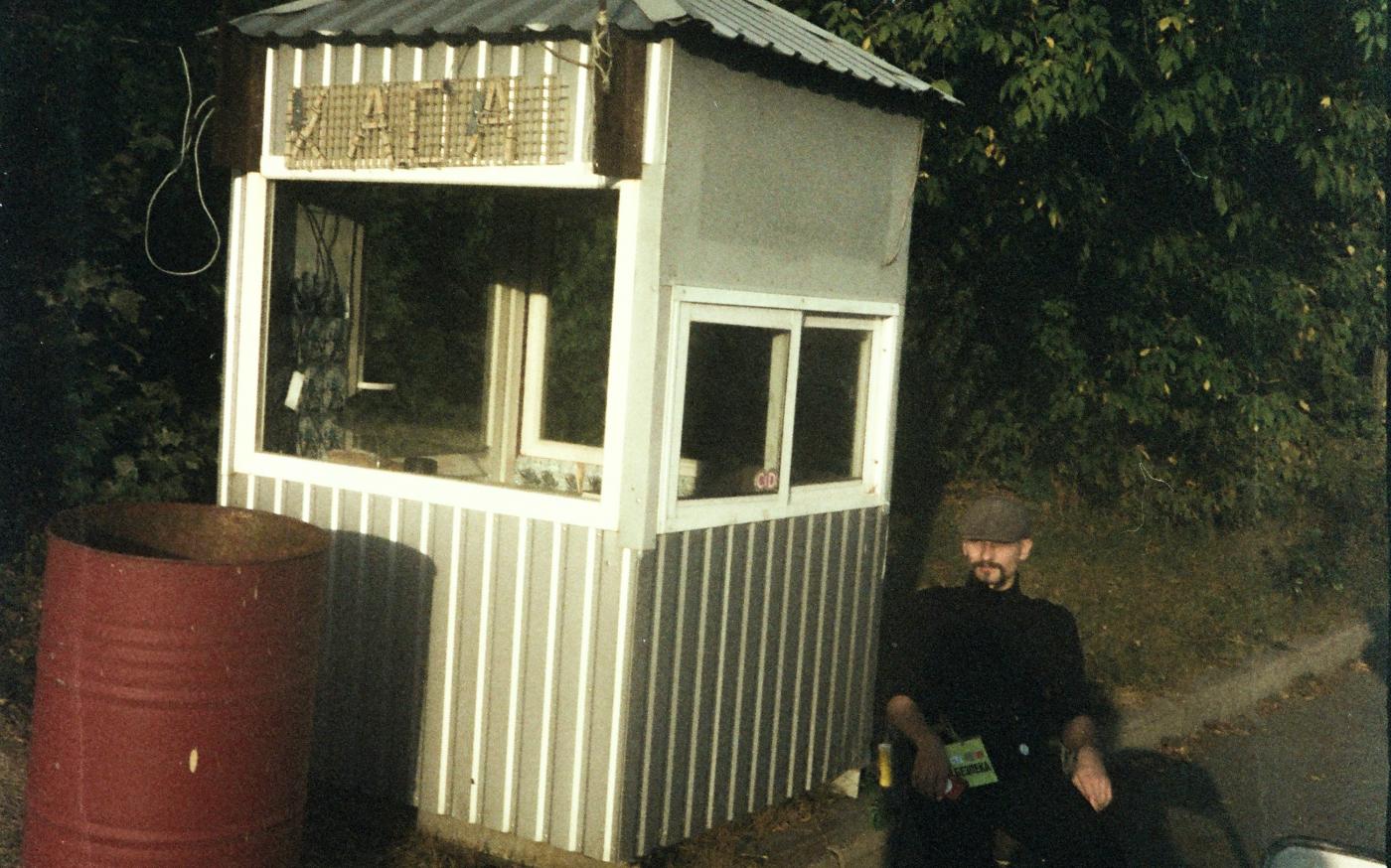 Man in uniform sits by guardhouse with sign. by Illia Horokhovsky courtesy of Unsplash.