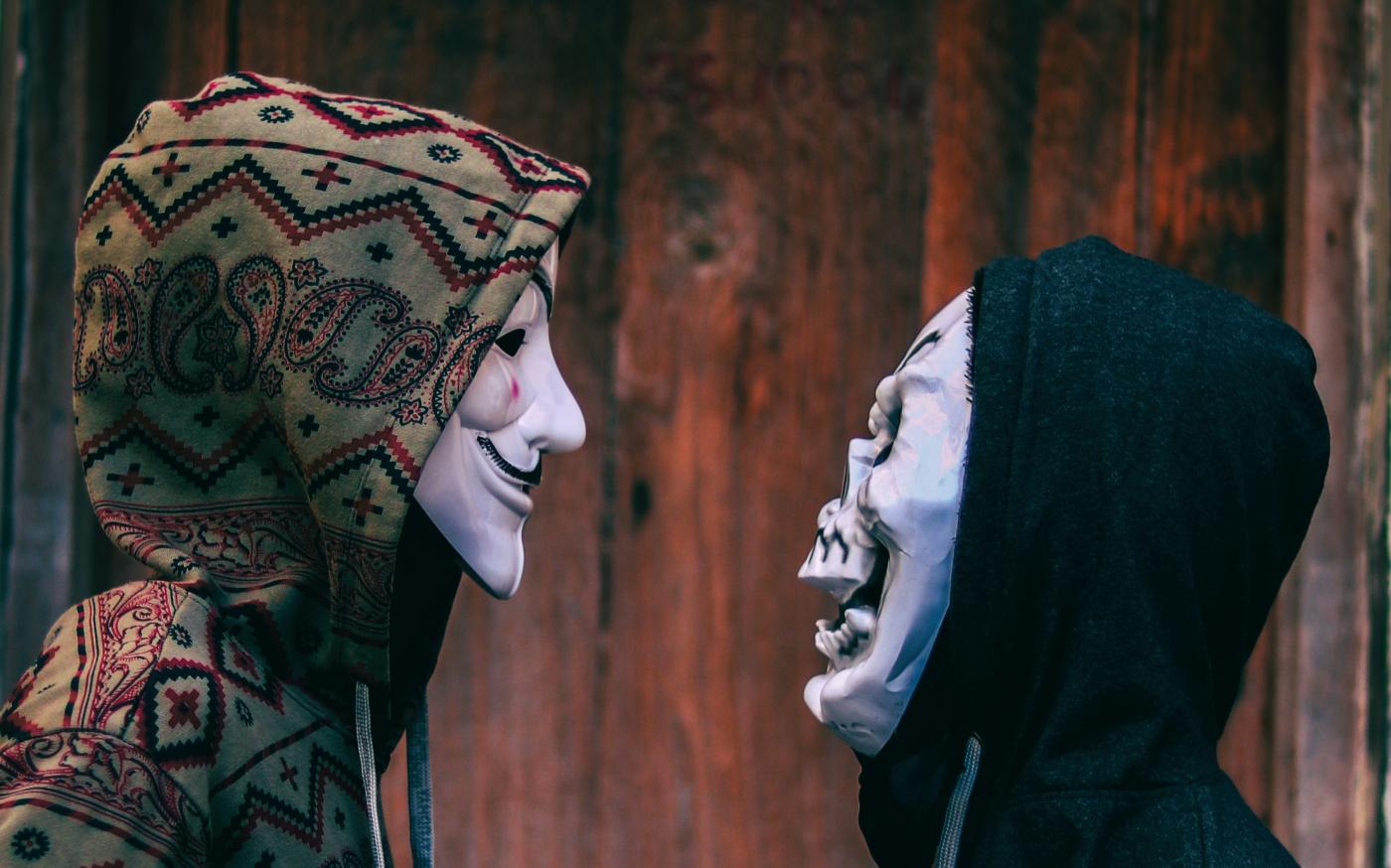 two person's facing each other near brown wooden wall by hmm 001 courtesy of Unsplash.