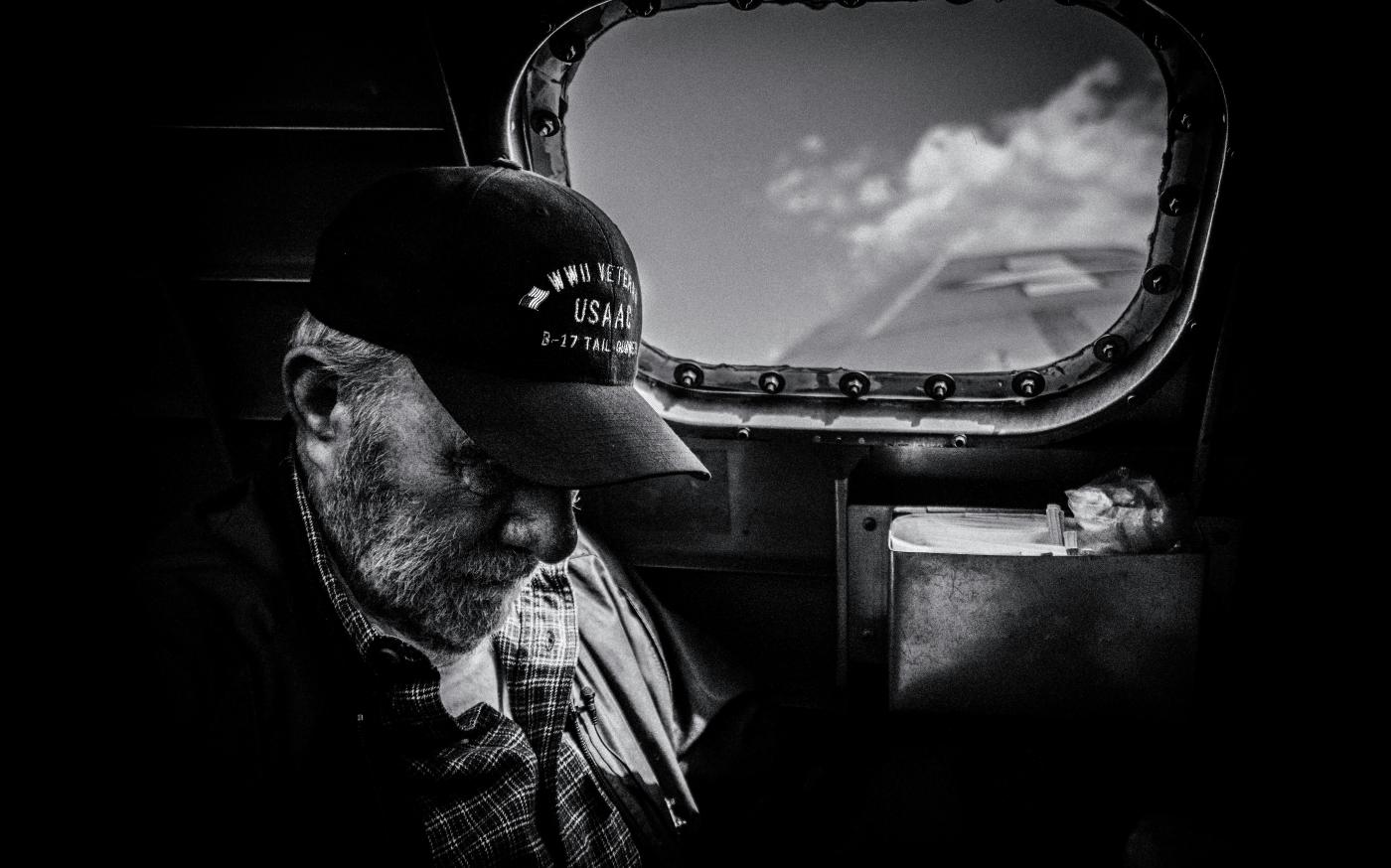 grayscale photo of man in plaid shirt and cap looking at the sky by Eric Ward courtesy of Unsplash.