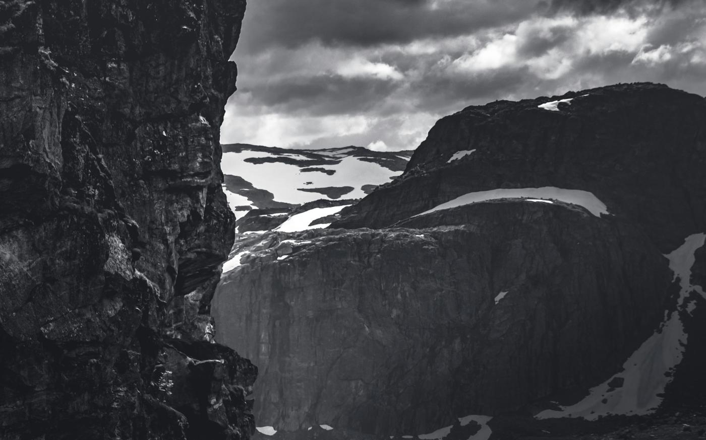 grayscale photo of rocky mountain under cloudy sky by Marek Piwnicki courtesy of Unsplash.