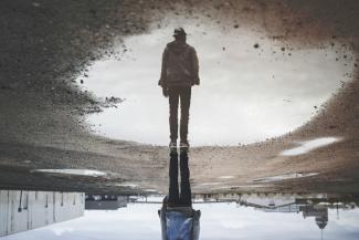 man's reflection on body of water photography by Randy Jacob courtesy of Unsplash.