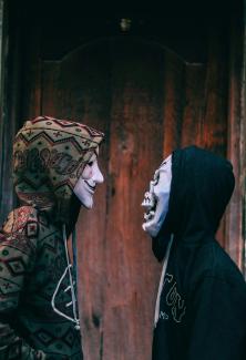 two person's facing each other near brown wooden wall by hmm 001 courtesy of Unsplash.