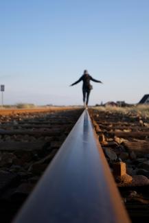 woman walking on train railway by Niklas Ohlrogge (niamoh.de) courtesy of Unsplash.