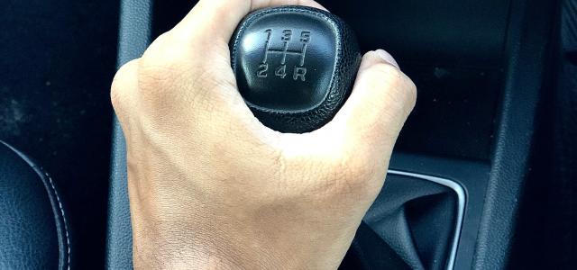person holding black car gear shift lever by DICSON courtesy of Unsplash.