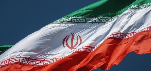 the flag of the country of iraq flying in the sky by sina drakhshani courtesy of Unsplash.