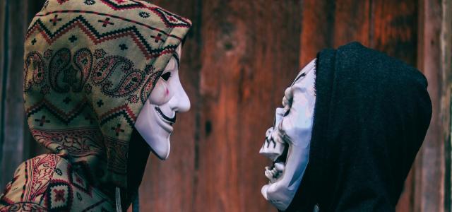 two person's facing each other near brown wooden wall by hmm 001 courtesy of Unsplash.