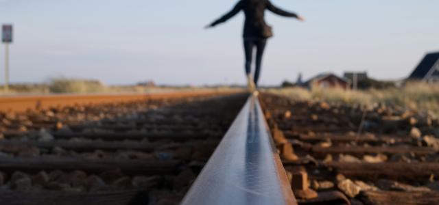 woman walking on train railway by Niklas Ohlrogge (niamoh.de) courtesy of Unsplash.
