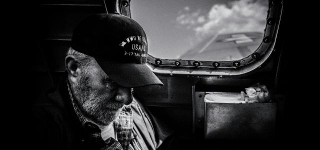 grayscale photo of man in plaid shirt and cap looking at the sky by Eric Ward courtesy of Unsplash.