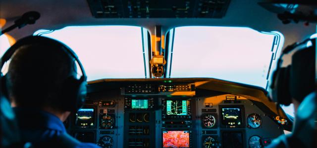 two men sitting on vehicle by Caleb Woods courtesy of Unsplash.