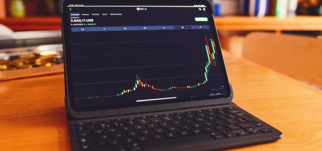 a laptop computer sitting on top of a wooden desk by rc.xyz NFT gallery courtesy of Unsplash.