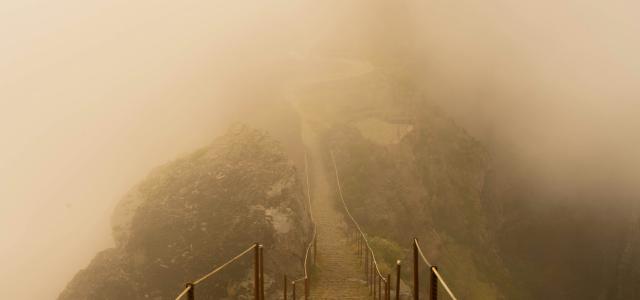 grayscale photo of bridge on mountain by Noah Grossenbacher courtesy of Unsplash.